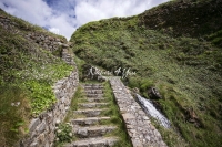 Stone wall stairway in a green valley near the coast in Normandy