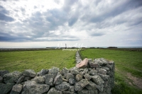 Urban Living: Dry stone wall with lighthouse by the coast of Normandy