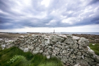 Urban Living: Dry stone wall with lighthouse by the coast of Normandy